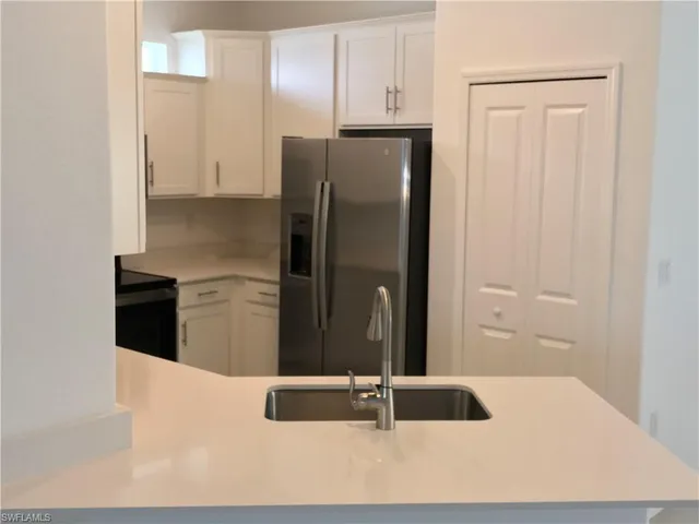 a kitchen with granite countertop a refrigerator and a sink