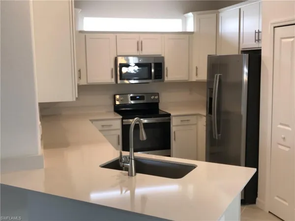 a kitchen with a refrigerator and a stove top oven