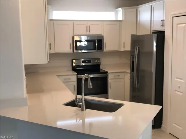 a kitchen with a refrigerator and a stove top oven