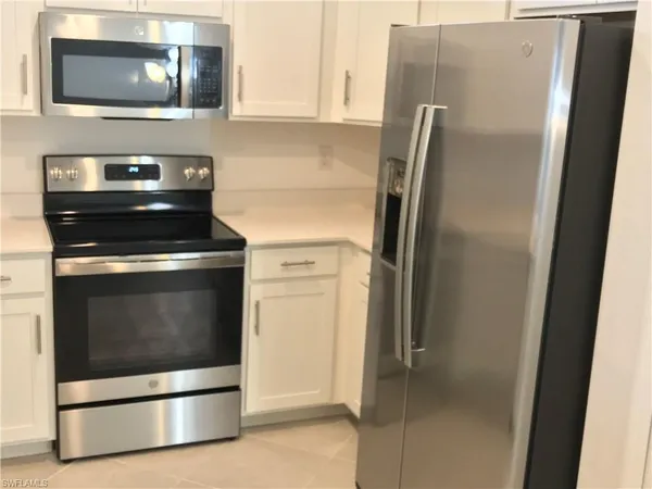 a kitchen with stainless steel appliances wooden floor sink and wooden cabinets