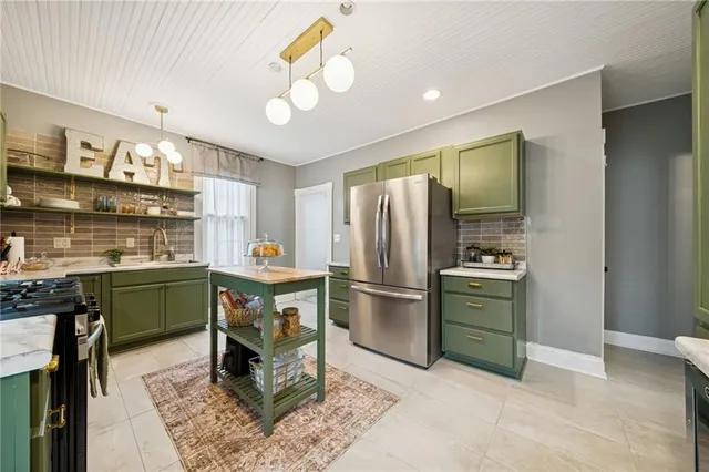 a kitchen with stainless steel appliances granite countertop a stove refrigerator sink and microwave
