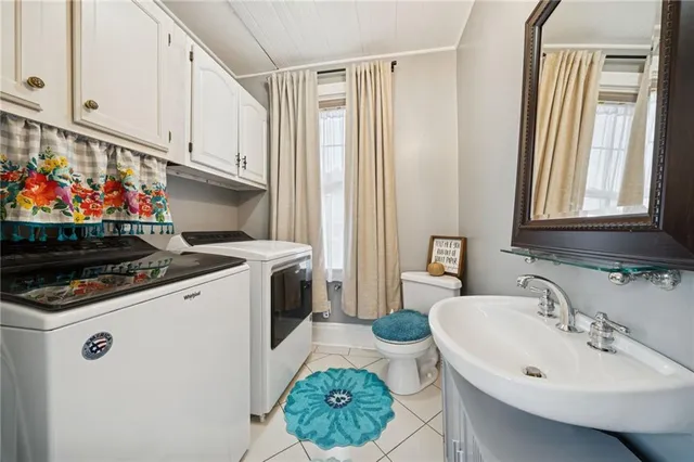 a spacious bedroom with a bed couch and a chandelier