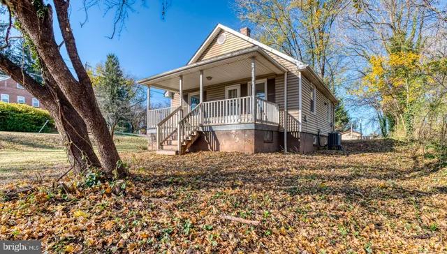 a view of a house with a yard and large tree