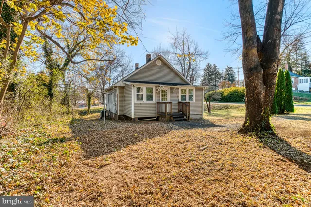 a front view of a house with a yard and large trees