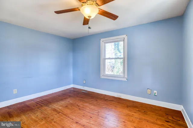 an empty room with a window and a ceiling fan
