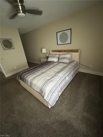 a bedroom with a bed and painting on the wall