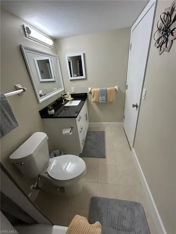 a bathroom with a toilet a sink and mirror