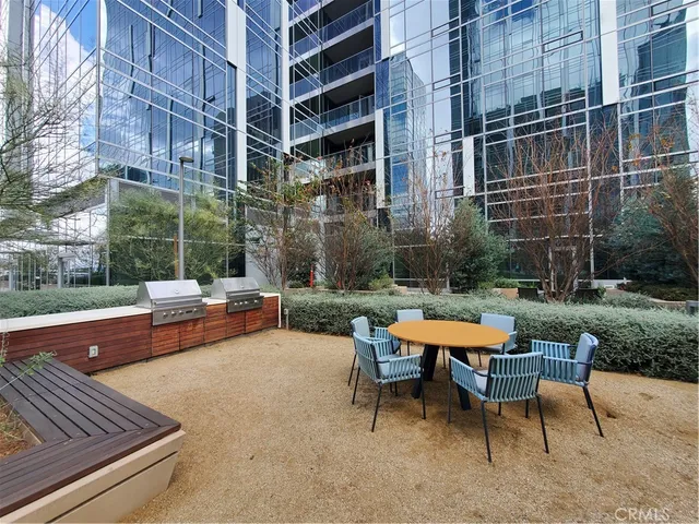 a backyard of a building with barbeque oven table and chairs