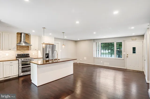 a kitchen with stainless steel appliances granite countertop a stove a sink and a refrigerator