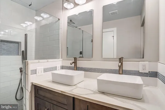 a bathroom with double vanity sink and a mirror
