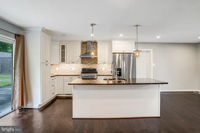 a kitchen with stainless steel appliances a refrigerator and a stove top oven