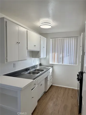 a kitchen that has a sink a stove and cabinets
