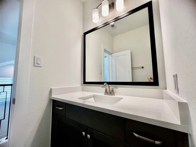 a bathroom with a sink vanity and a mirror