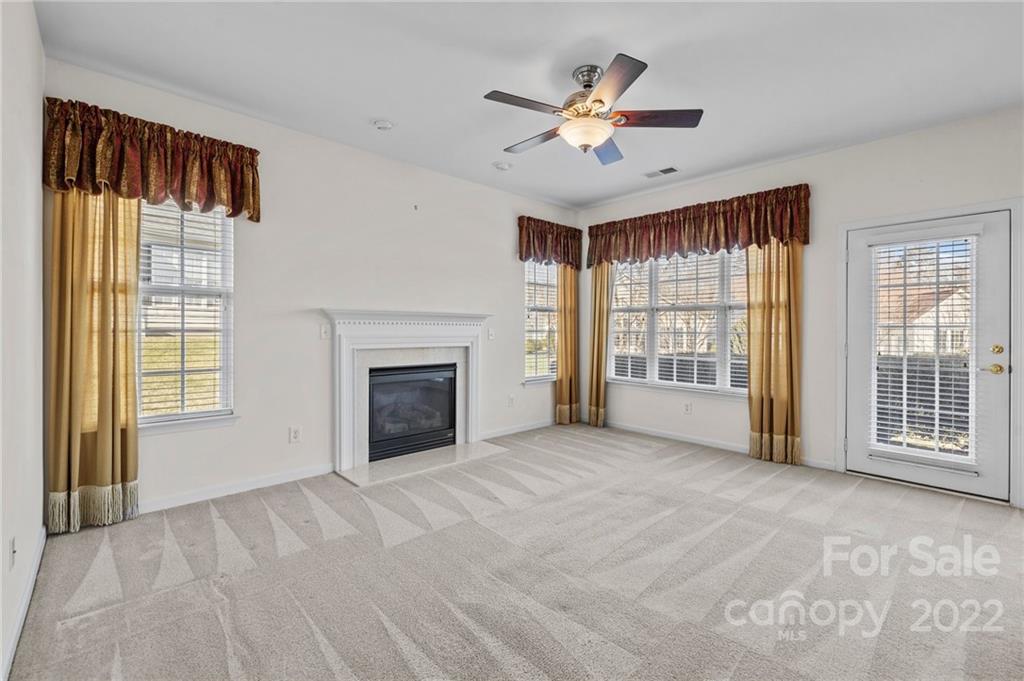 220 Garnet Court Fort Mill, SC 29708 - Photo 26 of 36 a view of an empty room with a fireplace and a window