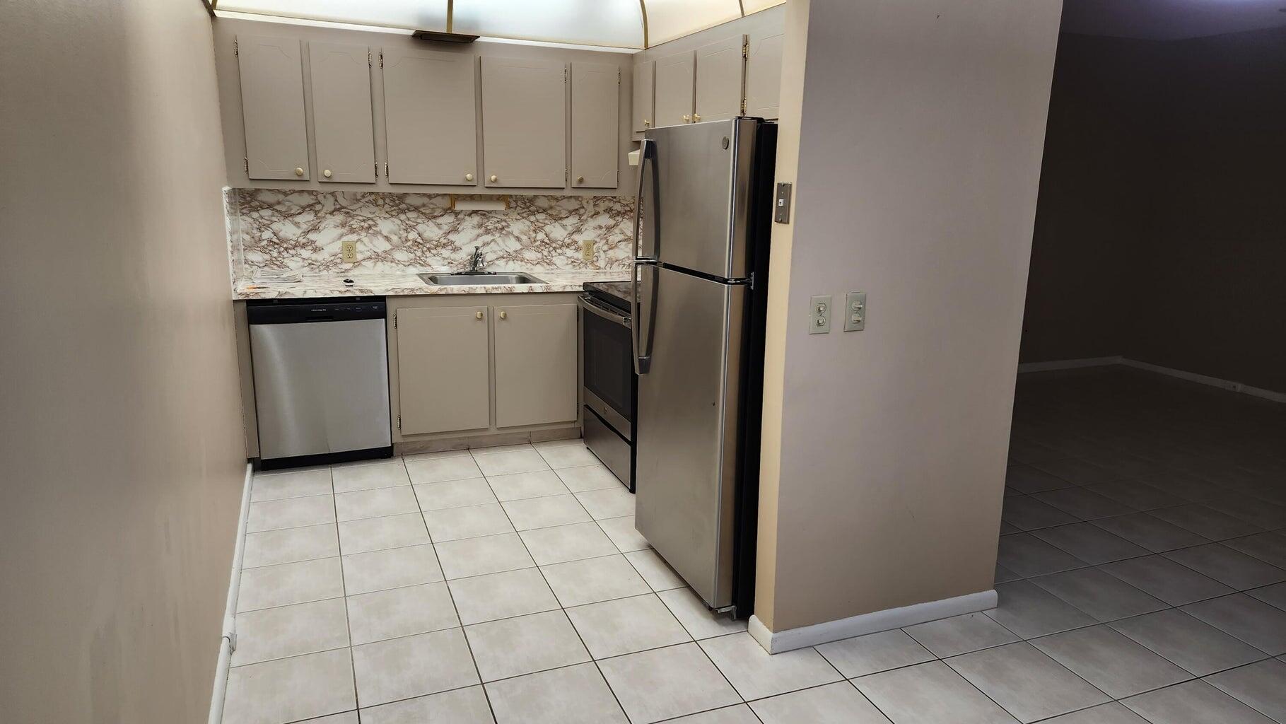 251 Fanshaw F Boca Raton, FL 33434 - Photo 1 of 14 a kitchen with a refrigerator sink and cabinets