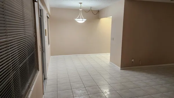 a view of a livingroom with an empty space and a kitchen