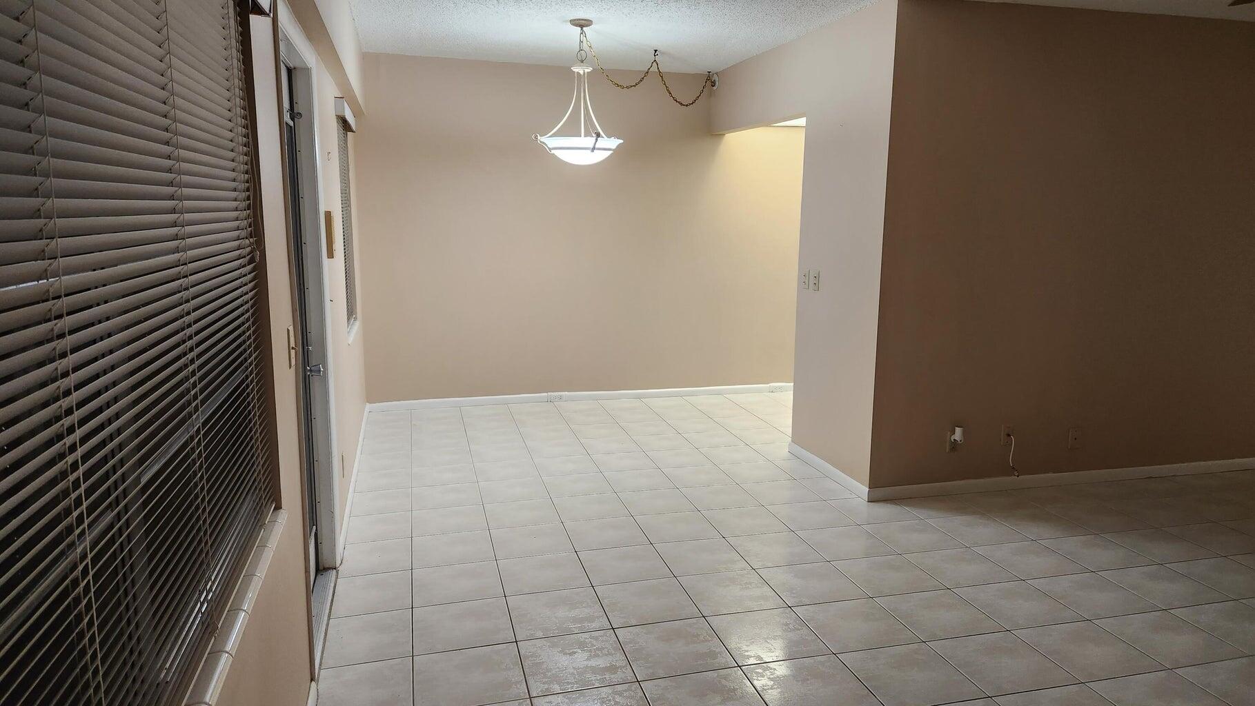 251 Fanshaw F Boca Raton, FL 33434 - Photo 2 of 14 a view of a livingroom with an empty space and a kitchen