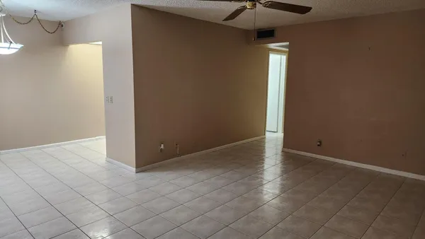 an empty room with a ceiling fan and carpet