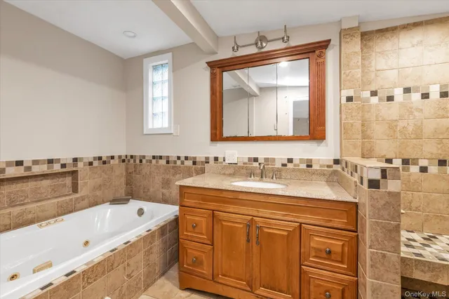 a bathroom with a tub sink and mirror