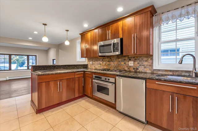 a kitchen with stainless steel appliances granite countertop a stove sink and microwave