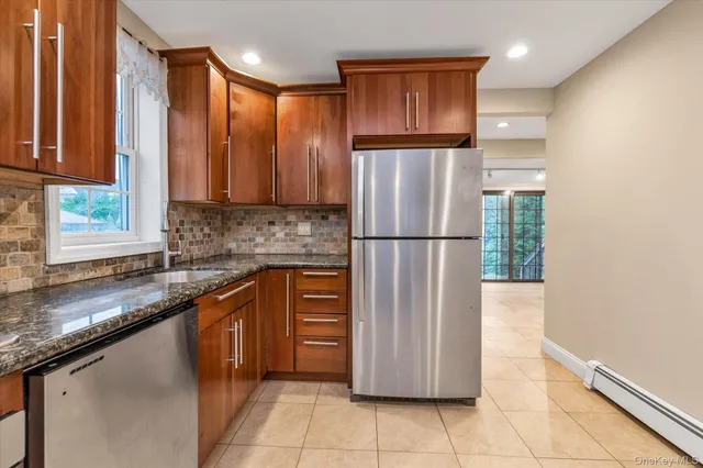 a kitchen with stainless steel appliances granite countertop a refrigerator a sink and a stove