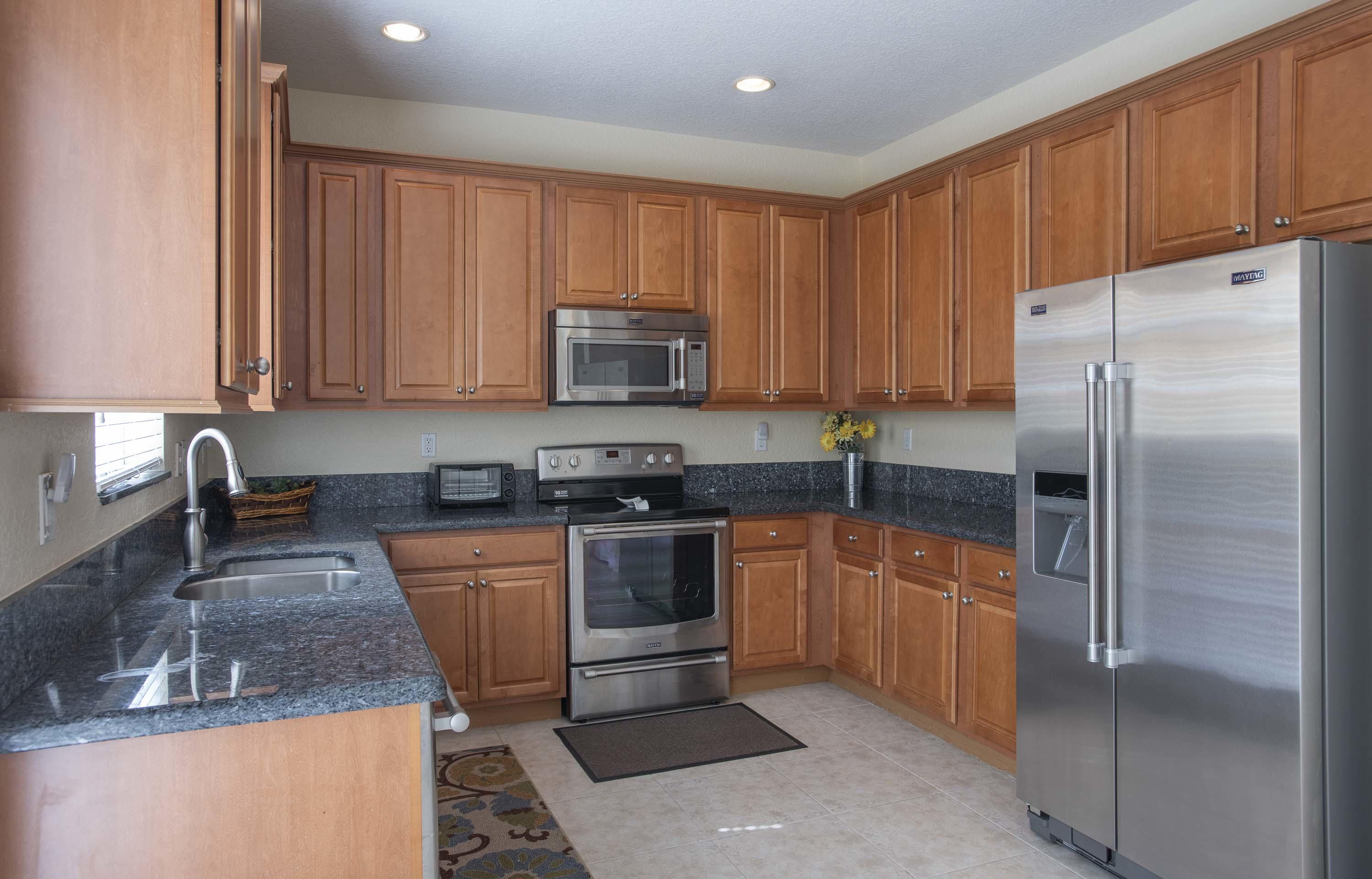 107 Mulligan Place Jupiter, FL 33458 - Photo 16 of 43 a kitchen with stainless steel appliances granite countertop a refrigerator stove and microwave