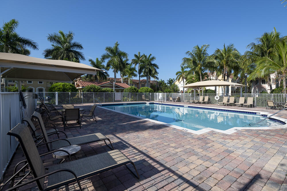 107 Mulligan Place Jupiter, FL 33458 - Photo 32 of 43 a view of a patio with table and chairs potted plants and palm tree