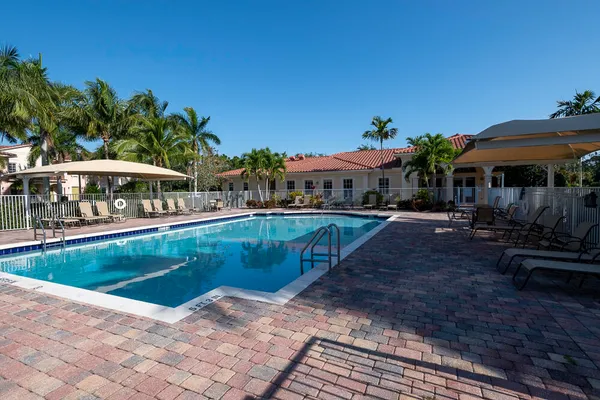a view of a swimming pool with lawn chairs under an umbrella