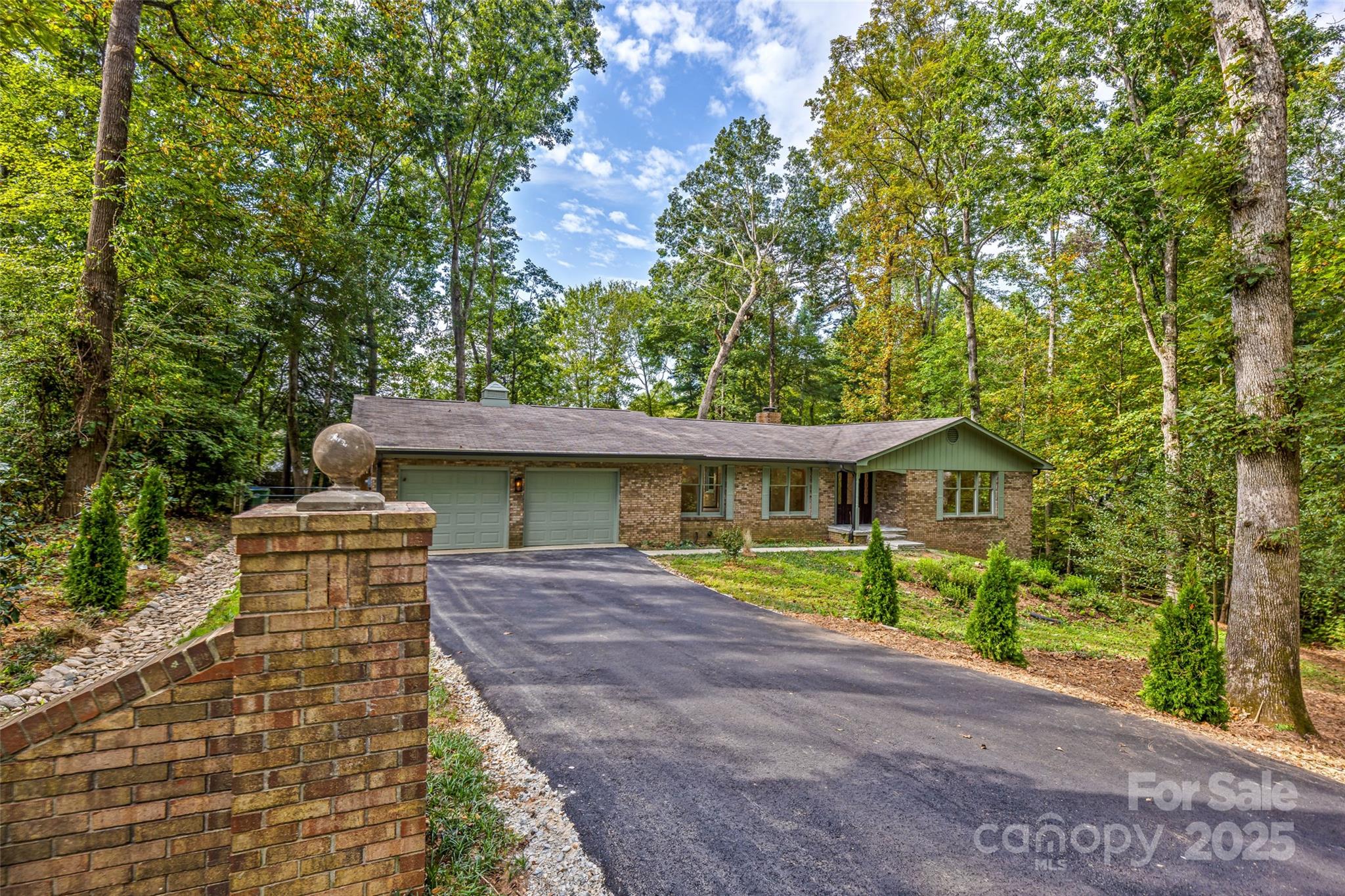 a view of a house with a yard and large trees