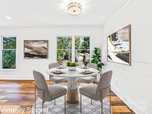 a view of a dining room with furniture a rug and wooden floor