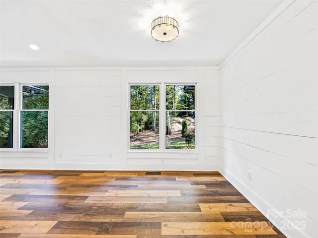 a view of a room with wooden floor and window