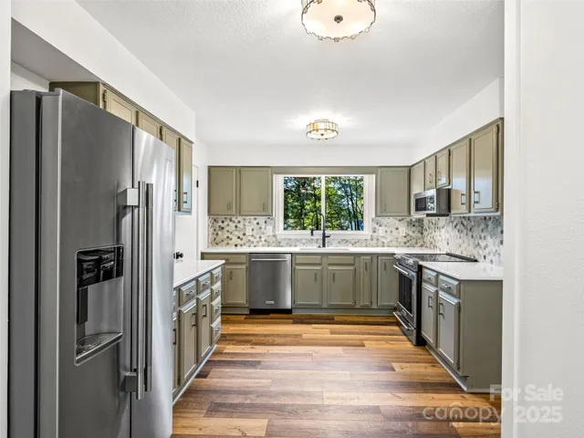 a kitchen with stainless steel appliances granite countertop a refrigerator and a stove top oven