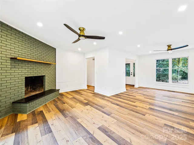 a view of empty room with wooden floor and fireplace
