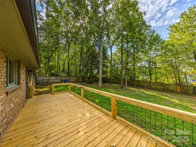 a view of a swimming pool with a patio and a yard