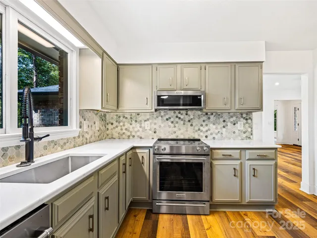a kitchen with stainless steel appliances granite countertop a sink stove and microwave