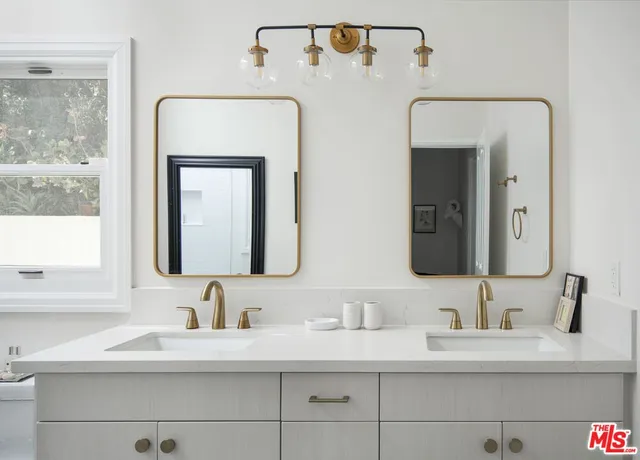 a bathroom with a double vanity sink mirror and