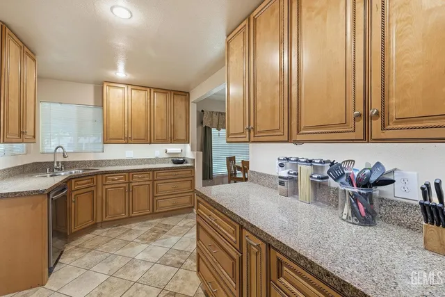 a kitchen with stainless steel appliances granite countertop a sink stove and cabinets