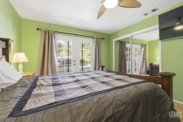 a bedroom with a bed mirror and a large window