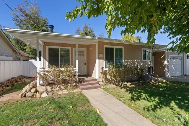 a view of a house with backyard sitting area and garden