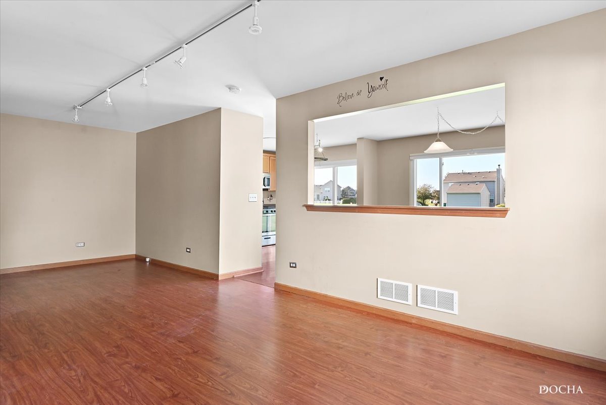 649 Chestnut Ridge Minooka, IL 60447 - Photo 3 of 20 an empty room with wooden floor and mirror
