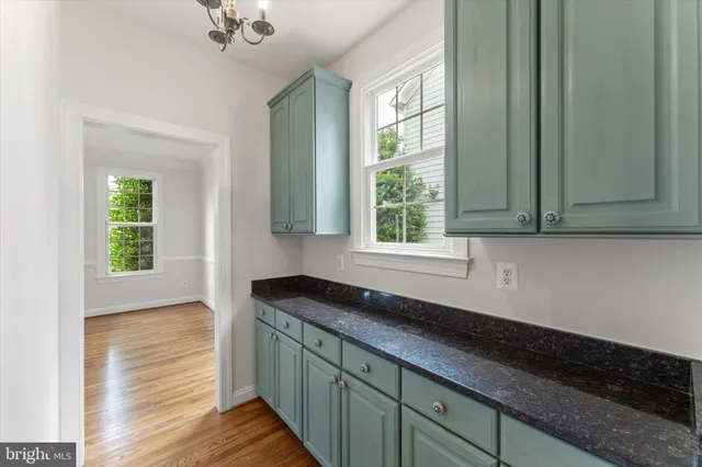 a kitchen with granite countertop cabinets a sink a window and stainless steel appliances