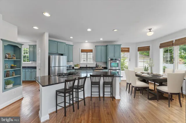 a view of a dining room with furniture wooden floor and a kitchen