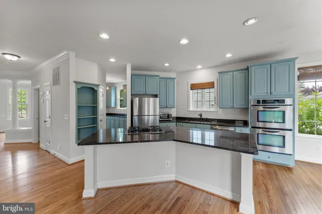 a kitchen with stainless steel appliances granite countertop a refrigerator and a stove top oven