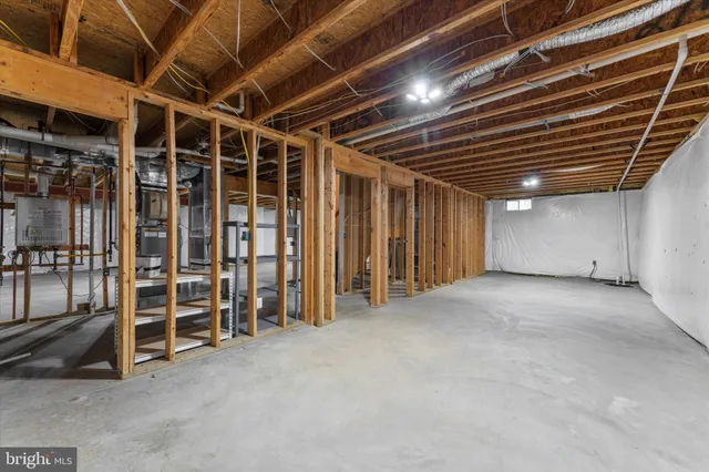 a view of a white house next to a yard with potted plants