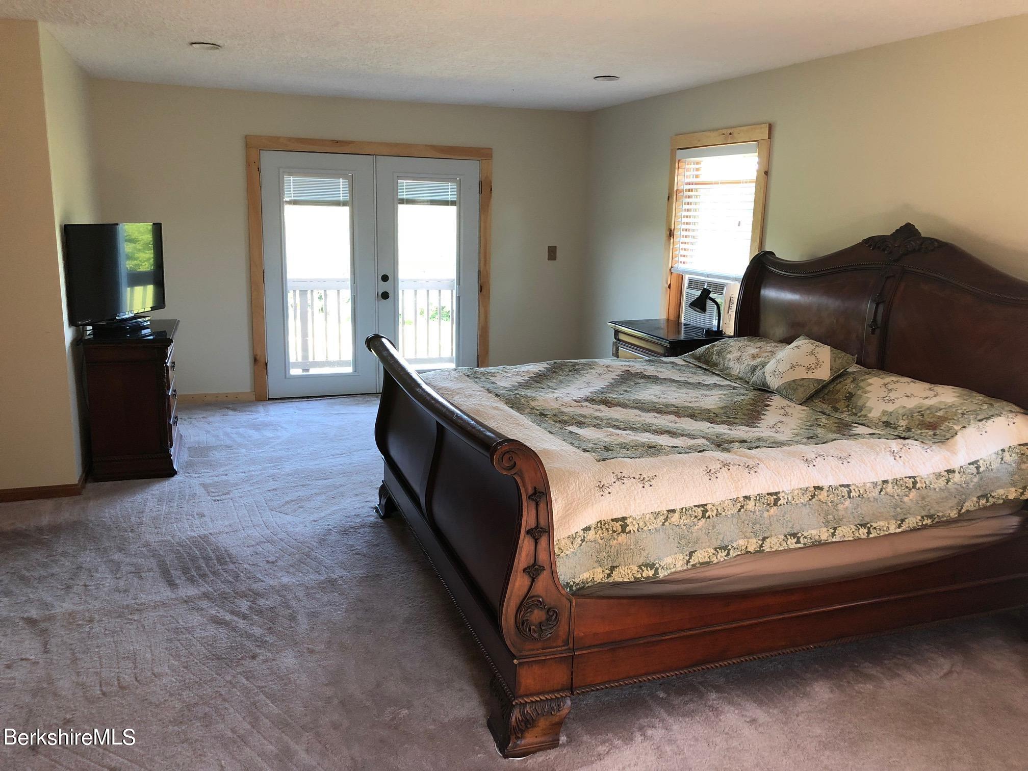 140 Arthur Pease Road Middlefield, MA 01011 - Photo 26 of 43 a bed sitting in a bedroom next to a window and dresser