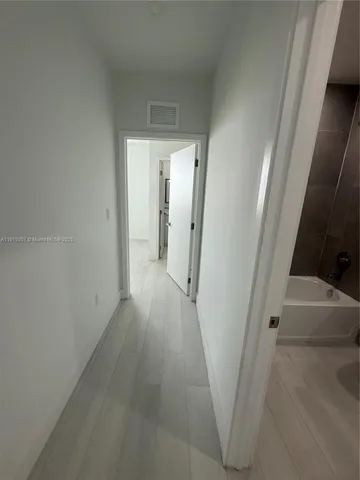 a view of a hallway with wooden floor and entryway