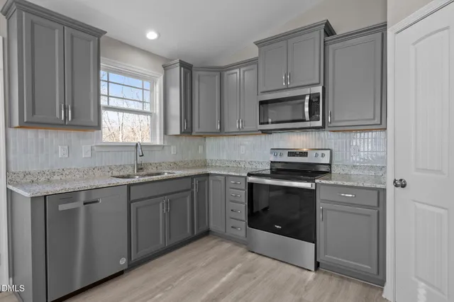 an empty room with wooden floor ceiling fan and window