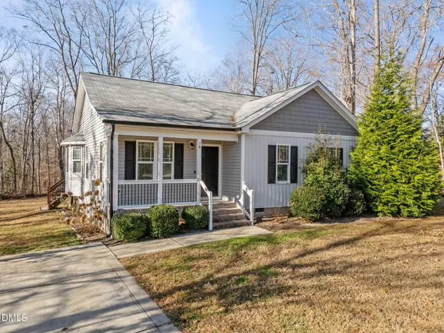 a front view of house with yard and outdoor seating