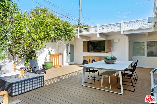 a living room with furniture a flat screen tv and kitchen view