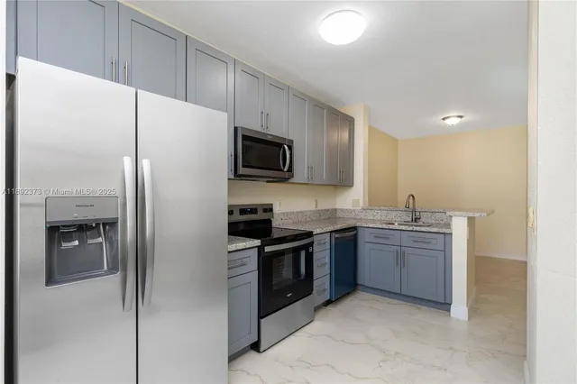 a kitchen with stainless steel appliances granite countertop a refrigerator and a stove top oven